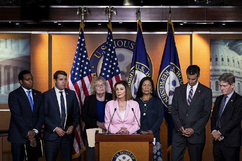 House Speaker Nancy Pelosi, surrounded by fellow Democratic House members, holds a news conference Friday in Washington to announce subpoenas for documents from Secretary of State Mike Pompeo and the scheduling of depositions from others in the State Department as part of the impeachment inquiry on President Donald Trump. More photos are available at arkansasonline.com/928pelosi/ 