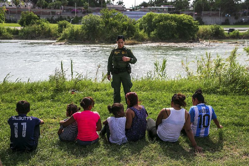 Women and children wait in May to be processed by Border Patrol personnel after they tried to cross illegally into the United States at Eagle Pass, Texas. New rules that would allow federal officials to detain unauthorized migrant children with their parents indefinitely were blocked Friday by a federal judge. 