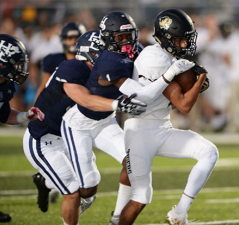 Bentonville receiver Chaz Nimrod (right) carries the ball after making a catch as Springdale Har-Ber cornerback JaJuan Boyd reaches to make the tackle during the first half Friday at Wildcat Stadium in Springdale. Bentonville won 35-21. For more photos, go to arkansasonline.com/928harber/. 