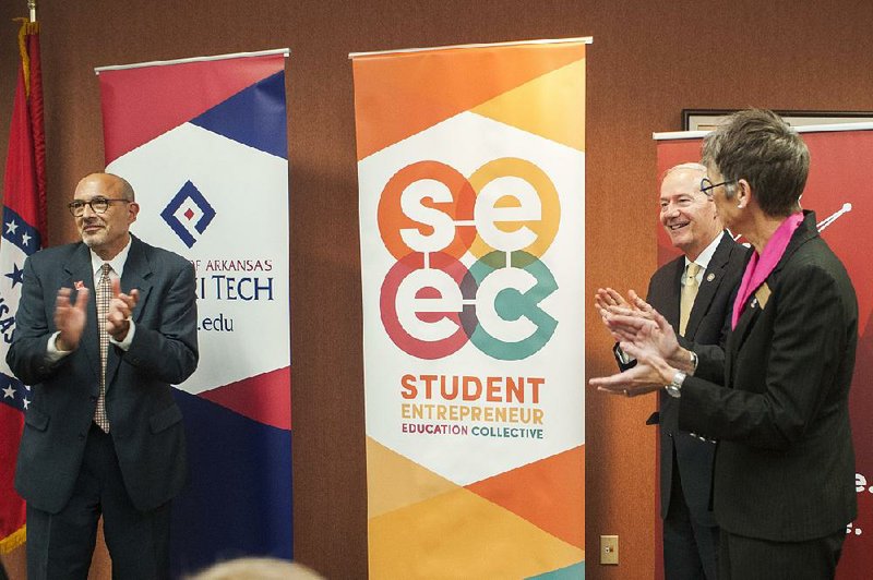 Little Rock Venture Center Executive Director Wayne Miller (from left), Gov. Asa Hutchinson and University of Arkansas-Pulaski Technical College Chancellor Margaret Ellibee unveil the Student Entrepreneur Education Collective during a Women In STEM workshop Friday at the school. 