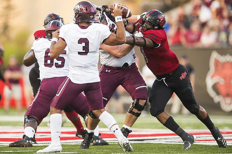 Arkansas State’s William Bradley-King tries to sack Southern Illinois quarterback Kare Lyles (3) during a Sept. 21 game at Centennial Bank Stadium in Jonesboro. Bradley-King is the only healthy start- ing defensive lineman for the Red Wolves with junior nose tackle Forrest Merrill done for the season with a torn bicep. 