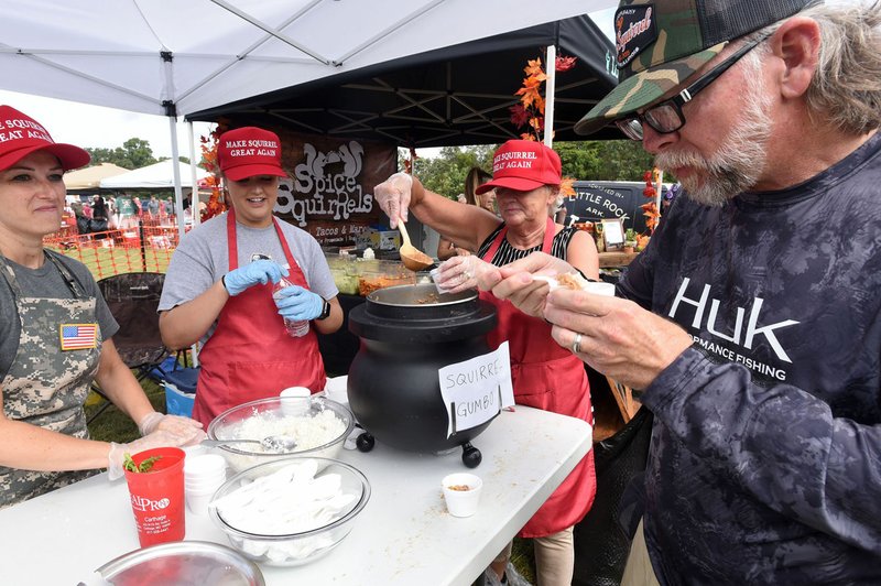 NWA Democrat-Gazette/FLIP PUTTHOFF David Mayhue of Lowell samples squirrel gumbo Sept. 21 2019 cooked up by squirrel chefs Ashley Ross (from left) Morgan Woods and Sarah Ross. Twenty-two teams competed for the top prize at the eighth annual World Championship Squirrel Cook-Off held near Bentonville.