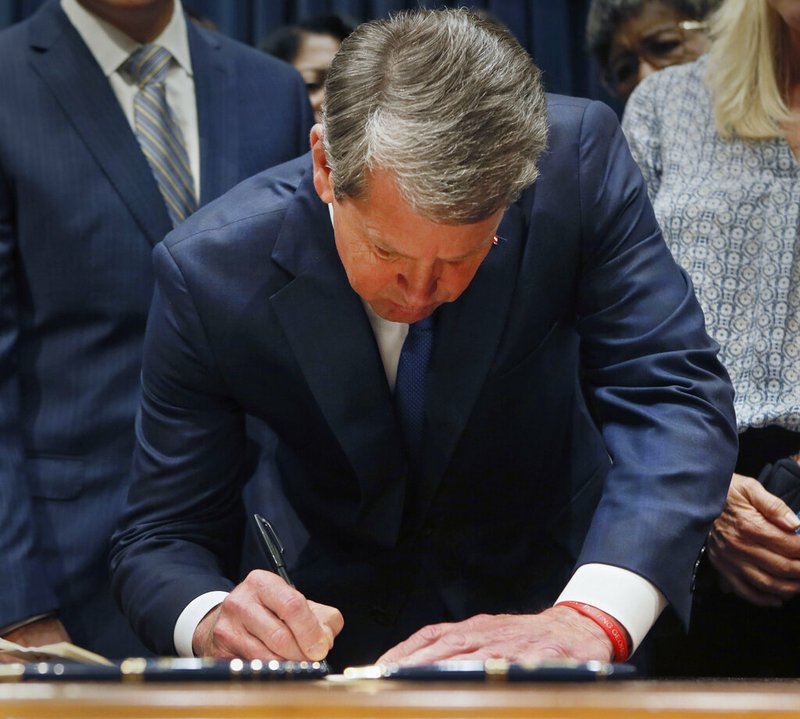 This May 7, 2019, file photo shows Georgia's Republican Gov. Brian Kemp signing legislation, in Atlanta, banning abortions once a fetal heartbeat can be detected. A federal judge on Tuesday, Oct. 1, 2019, temporarily blocked Georgia's restrictive new abortion law from taking effect, following the lead of other judges who have blocked similar measures in other states. The law signed in May by Republican Gov. Brian Kemp bans abortions once a fetal heartbeat is detected, which can happen as early as six weeks into a pregnancy, before many women realize they're expecting. It allows for limited exceptions. (Bob Andres/Atlanta Journal-Constitution via AP, File)