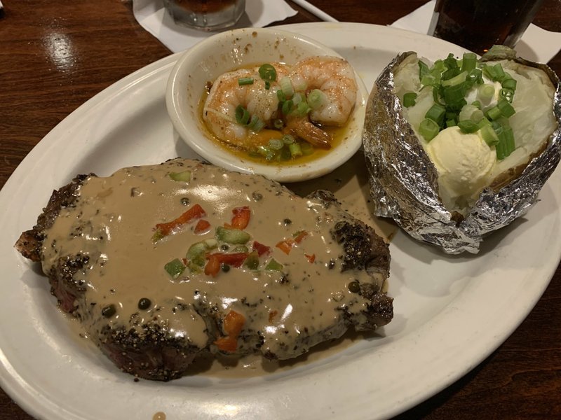 For a recent weekend special, The Butcher Shop paired its 12-inch rib-eye with three Cajun shrimp; ordered au poivre, it comes topped with peppercorns and brandy demi-glace specked with bits of green and red bell peppers. Arkansas Democrat-Gazette/Eric E. Harrison