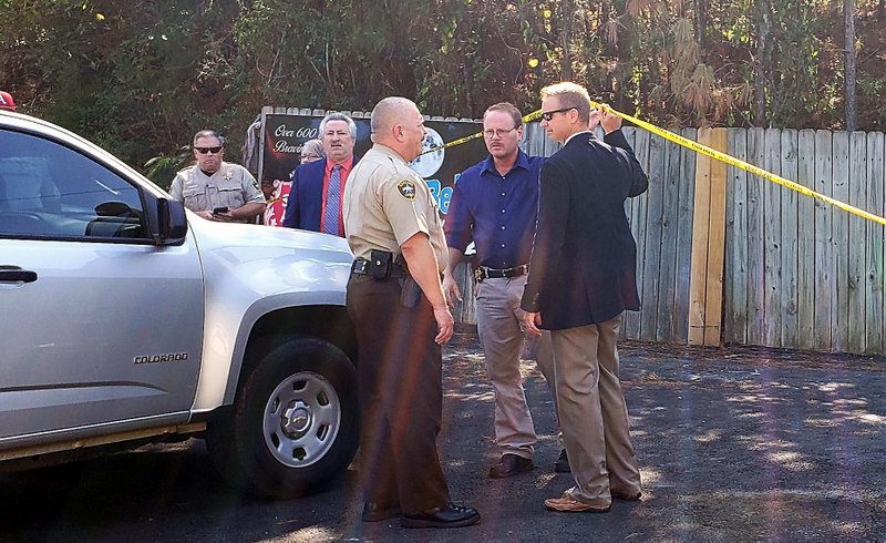 Garland County sheriff's Capt. Joel Ware, center, left, and Under Sheriff Jason Lawrence, far right, talk Wednesday morning at the scene where a first-degree murder suspect, identified as Vincent Bernard Louis, 41, was arrested in the 5000 block of Central Avenue. - Photo by Grace Brown of The Sentinel-Record