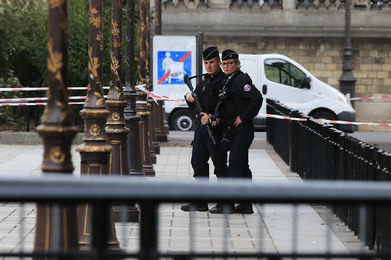 Officers stand guard Thursday outside Paris police headquarters after a knife attack inside. 