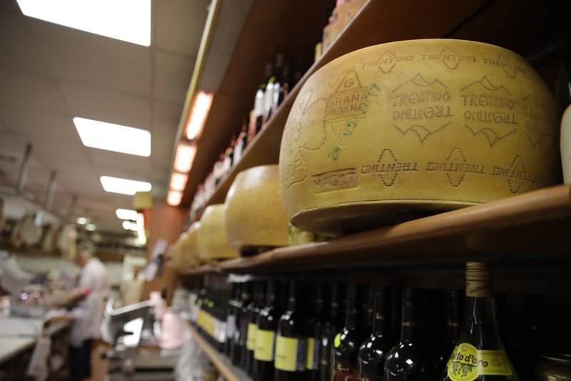 Wheels of parmesan cheese are stored in a deli in Rome, Thursday, Oct. 3, 2019. The U.S. had prepared for Wednesday's ruling and already drawn up lists of the dozens of goods it would put tariffs on. They include EU cheeses, olives, and whiskey, as well as planes, helicopters and aircraft parts in the case _ though the decision is likely to require fine-tuning of that list if the Trump administration agrees to go for the tariffs. (AP Photo/Alessandra Tarantino)