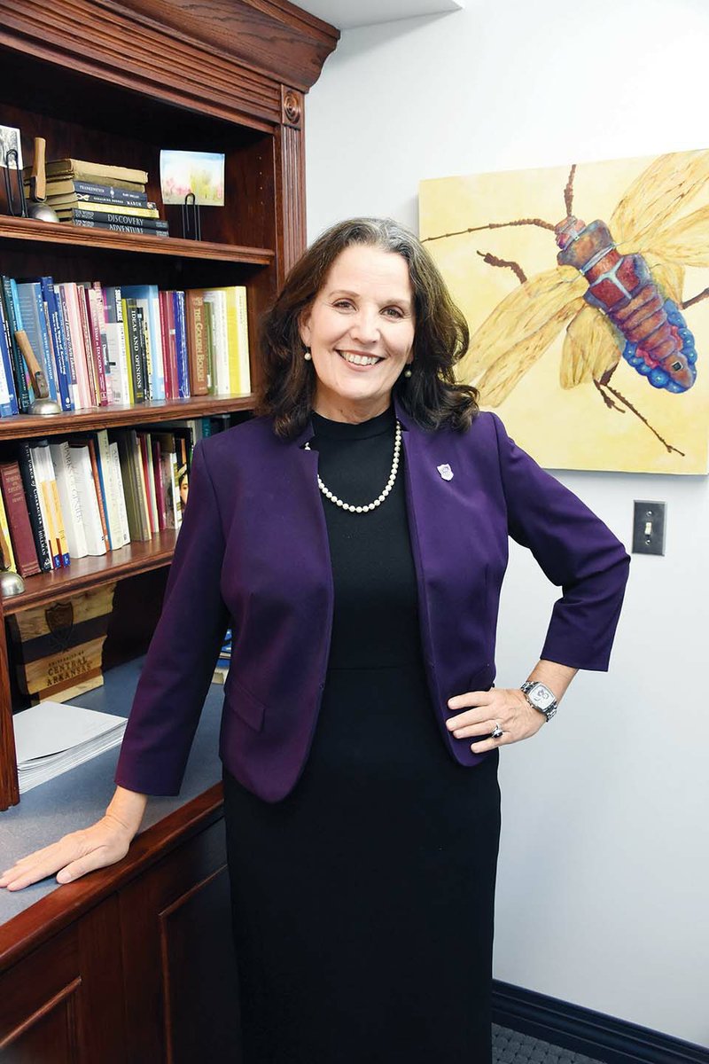 Patty Poulter, provost and executive vice president of academic affairs at the University of Central Arkansas in Conway, stands in her office in front of artwork created by her daughter Annie Cunningham. Poulter, 60, started in the position in July 2018. In July this year, she was diagnosed with two kinds of breast cancer. She said the Conway and UCA communities have been caring and supportive. “I love it here,”she said.