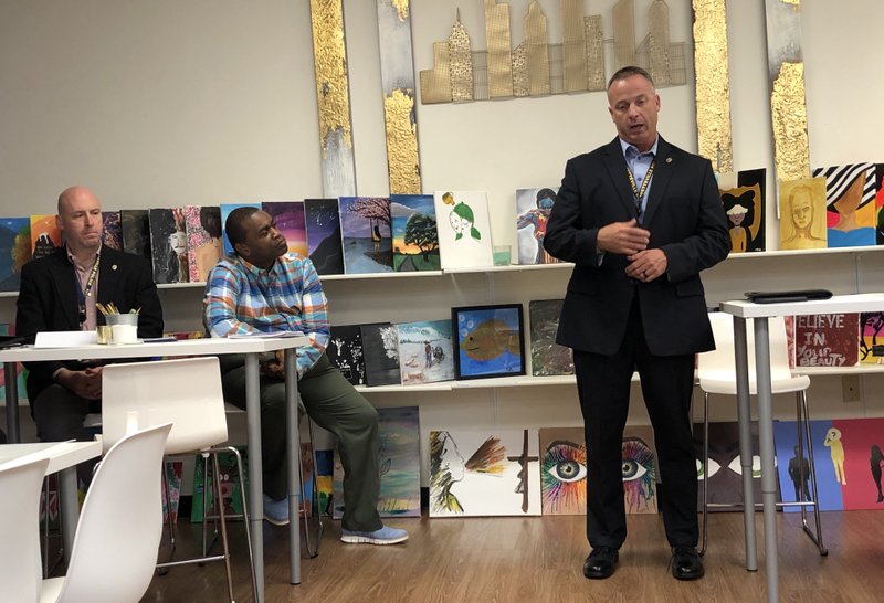 NWA Democrat-Gazette/STACY RYBURN Mike Reynolds (right), Fayetteville police chief, speaks Thursday at My-T-By-Design, 392 E. Sunbridge Drive, while Officer Brad Renfro (left) and D'Andre Jones (middle), chairman of the city's African American Advisory Council, look on. The council invited Reynolds to have a discussion about quality of life for the city's black community.