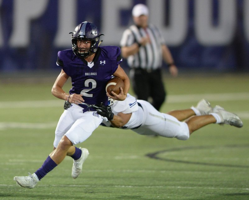 NWA Democrat-Gazette/ANDY SHUPE Fayetteville receiver Connor Flannigan (2) carries the ball Friday, Oct. 4, 2019, as Rogers linebacker Jesus Gomez attempts to make the tackle during the first half of play at Harmon Stadium in Fayetteville. Visit nwadg.com/photos to see more photographs from the game and the homecoming ceremony.