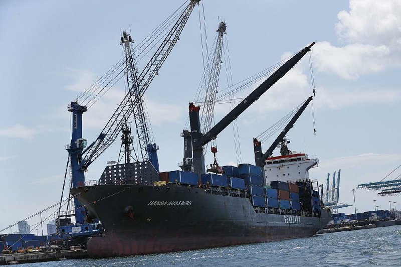 The container ship Hansa Augsburg is docked in Miami in July. The Commerce Department said Friday that the gap between what the United States imports and what it exports rose in August after declines in June and July. 