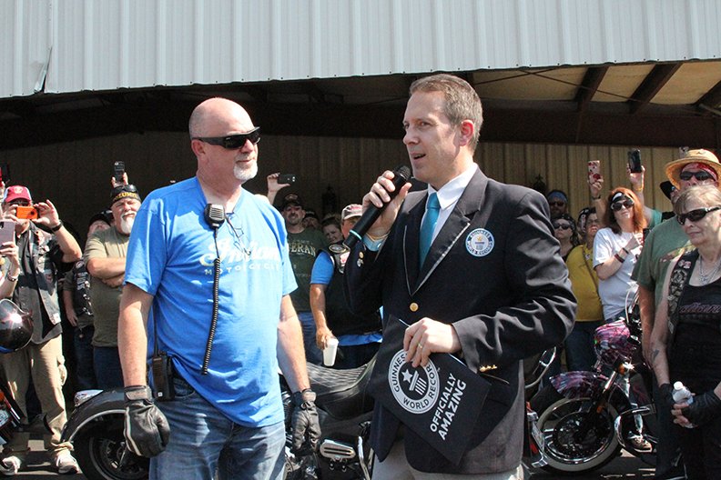 Philip Robertson, an adjudicator with Guinness World Records, informs parade organizer Rob Gregory that a group of Indian motorcycle owners from across the country had broken a world record Saturday in Hot Springs. - Photo by Tanner Newton of The Sentinel-Record