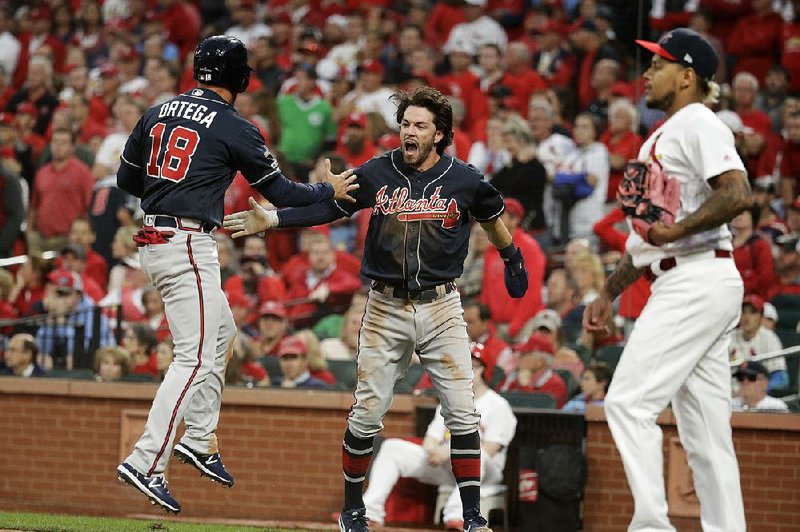 Atlanta Braves' Dansby Swanson, center, and Rafael Ortega, right