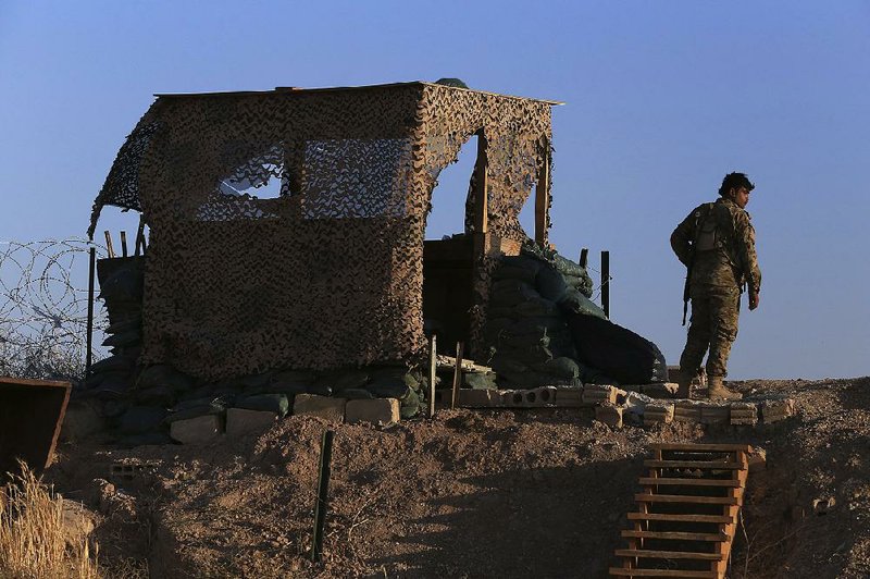 A fighter from the Kurdish-led Syrian Democratic Forces stands Monday at a post in Tel Abyad used by U.S. troops before their withdrawal. More photos are available at arkansasonline.com/108syria/ 