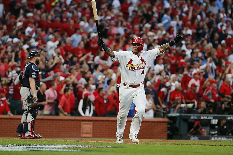 St. Louis’ Yadier Molina (shown) celebrates after hitting a sacrifice fly in the 10th inning to bring in Kolten Wong for the winning run to give the Cardinals a 5-4 victory over the Atlanta Braves in their National League division series Monday in St. Louis. The series is tied at 2-2, with the deciding game set for Wednesday in Atlanta.