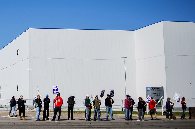 General Motors employees with picket signs line the street outside the company’s Flint, Mich., assembly plant Monday. For more photos, go to arkansasonline.com/108gm/ 