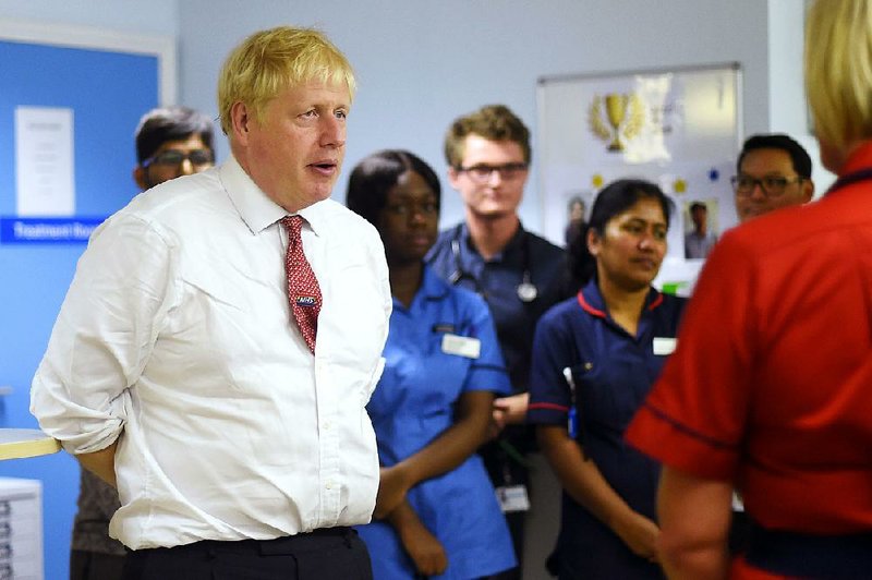 British Prime Minister Boris Johnson speaks to mental health professionals Monday during a visit to Watford General Hospital in Watford, England. More photos are available at arkansasonline.com/108brexit/