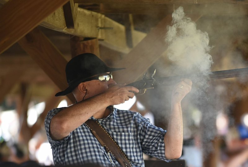 NWA Democrat-Gazette/FLIP PUTTHOFF Mark Noah of Springfield, Mo., fires at a target during the Saunders Memorial Shoot in Berryville.
