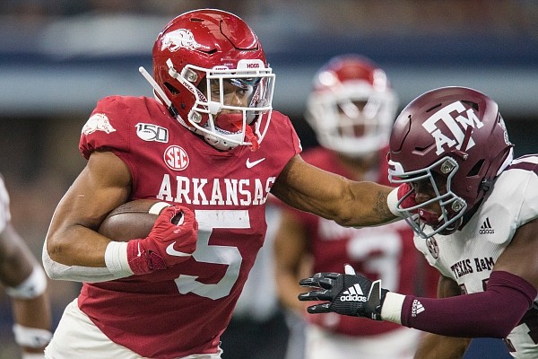 Rakeem Boyd, Arkansas running back, stiff-arms Keldrick Carper, Texas A&M safety, on a run in first quarter Saturday, Sept. 28, 2019, at AT&T Stadium in Arlington, Texas.