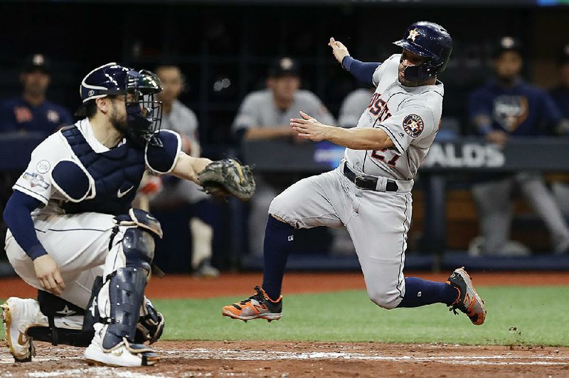 Houston infielder Jose Altuve (right) attempts to score but is tagged out by Tampa Bay catcher Travis d’Arnaud during the fourth inning of the Astros’ 4-1 loss to the Rays in Game 4 of their American League division series at Tropicana Field in St. Petersburg, Fla. 