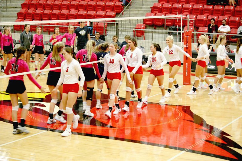 MARK HUMPHREY ENTERPRISE-LEADER Farmington and Shiloh Christian varsity volleyball teams shake hands before their match on Tuesday, Oct., 2019 at Cardinal Arena. Farmington swept the Lady Saints, 25-17, 25-23, 27-25, to claim its first-ever 3-set victory over Shiloh Christian in volleyball.
