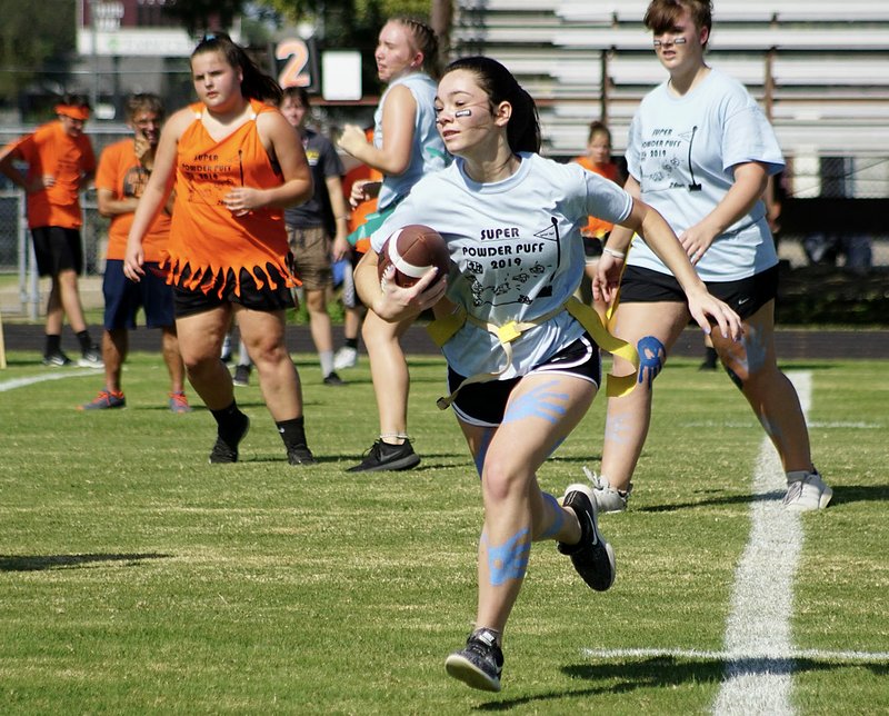 Westside Eagle Observer/RANDY MOLL Gentry senior Ahrya Reding carries the ball for the seniors after a handoff from Allee Sweeten during the powderpuff football games on Oct. 2 at Gentry High School.