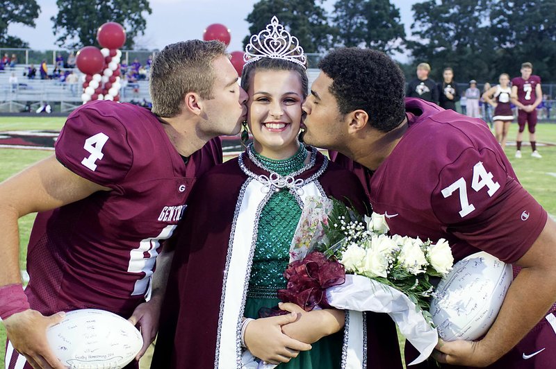 Westside Eagle Observer/RANDY MOLL Gentry High School homecoming captains Brandon Atwood and Kerlose Ruzek give a ceremonial kiss to newly-crowned 2019 homecoming queen Falyn Cordeiro at ceremonies in Gentry on Friday night.