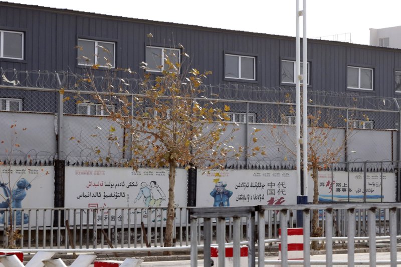 In this Dec. 5, 2018, file photo, two layers of barbed wire fencing ring the "Hotan City apparel employment training base"where Hetian Taida Apparel Co. has a factory in Hotan in western China's Xinjiang region. The Trump Administration is blocking shipments from Chinese company Hetian Taida Apparel, which makes baby pajamas sold at Costco warehouses, after the foreign manufacturer was accused of forcing ethnic minorities locked in an internment camp to sew clothes against their will. (AP Photo/Ng Han Guan, File)