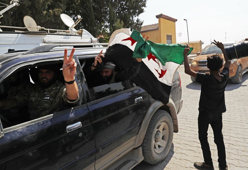 Members of Turkey-backed Syrian National Army (former FSA) flash the V-sign as they drive back to Turkey after they went in for some time on inspection according to the Turkish police entourage in the same area at the border between Turkey and Syria, in Akcakale, Sanliurfa province, southeastern Turkey, Wednesday, Oct. 9, 2019.  