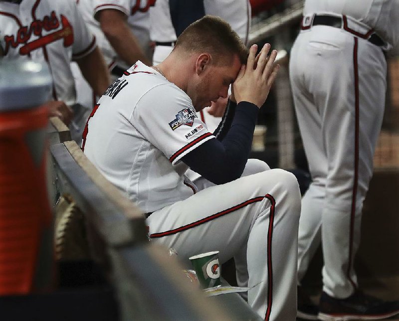 Freddie Freeman of the Atlanta Braves sits in the dugout during the ninth inning of the Braves’ 13-1 loss to the St. Louis Cardinals on Wednesday during Game 5 of their National League division series. The Cardinals scored 10 runs in the first inning, a postseason record. 