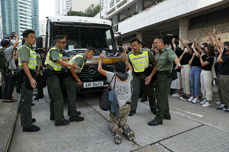 A supporter of Edward Leung kneels to stop a police van carrying the political activist Wednesday outside the High Court in Hong Kong. More photos are available at arkansasonline.com/1010protest/ 