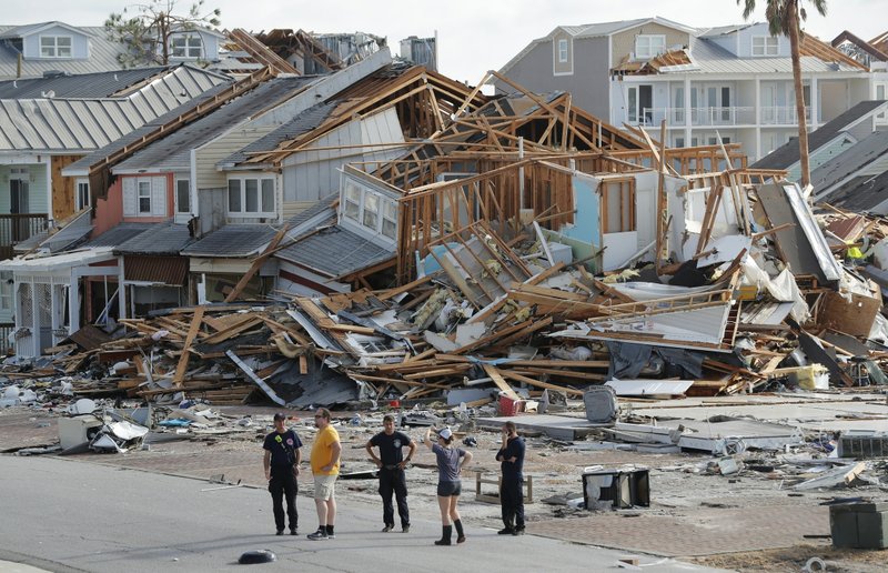In this Oct. 11, 2018 file photo, rescue personnel perform a search in the aftermath of Hurricane Michael in Mexico Beach, Fla. A year after Hurricane Michael, Bay County, Florida, is still in crisis. Thousands are homeless, medical care and housing are at a premium, and domestic violence is increasing. Michael was among the strongest hurricanes ever to make landfall in the United States. This summer, county officials unveiled a blueprint to rebuild. Among their ideas: Use shipping containers and 3-D technology to build new houses and offer signing bonuses to lure new doctors. - Photo by Gerald Herbert/File photo of The Associated Press