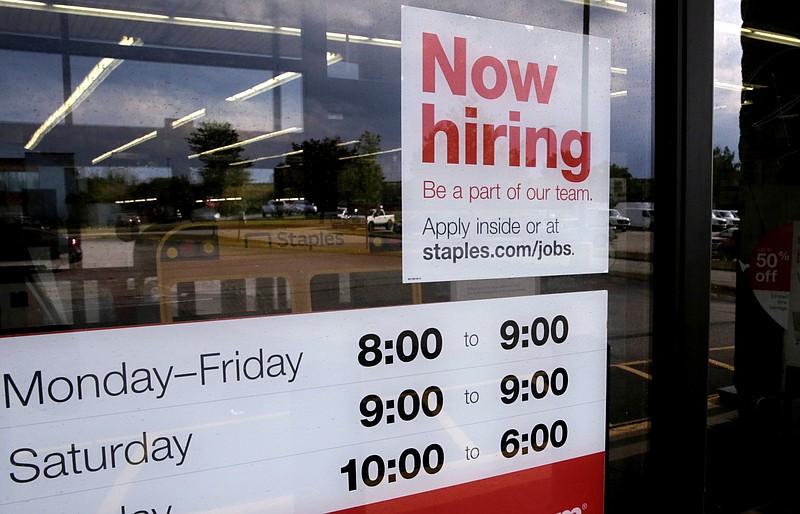 A "Now Hiring" sign is displayed on the front door of a Staples store in Manchester, N.H., in this Aug. 15, 2019, file photo. (AP Photo/Charles Krupa, File)