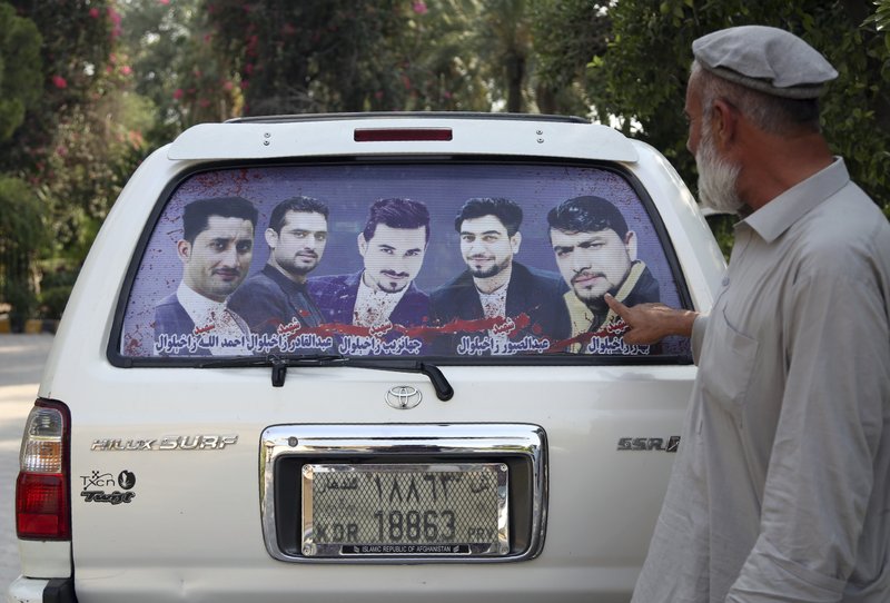 In this Tuesday, Oct. 1, 2019, photo, Zakhiwal's uncle, Mohammad Yaqoob Malikzada shows pictures of four brothers in the back of his car, who ware killed during a raid by the Afghan soldiers trained by CIA only known as Unit 02 after an interview to the Associated Press in Jalalabad city east of Kabul, Afghanistan, Anger is mounting over the increasing numbers of civilians dying in misdirected US aerial strikes and heavy- handed tactics of CIA-trained Afghan force. (AP Photo/Rahmat Gul)