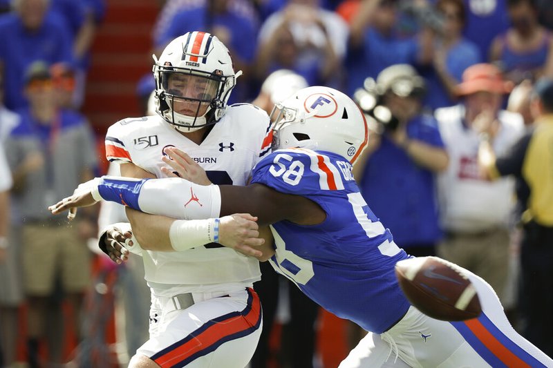 Auburn quarterback Bo Nix, left, is hit by Florida linebacker Jonathan Greenard (58) as he releases the ball during the first half of an NCAA college football game, Saturday, Oct. 5, 2019, in Gainesville, Fla. (AP Photo/John Raoux)