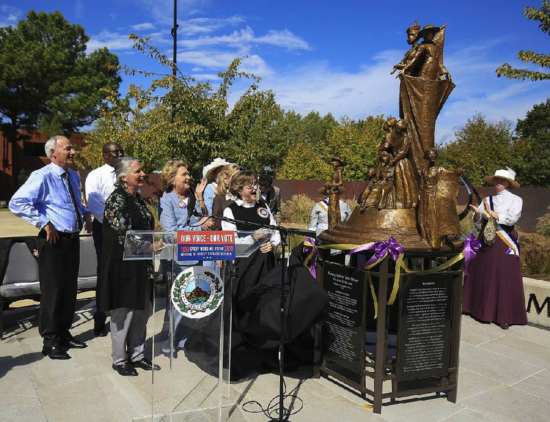 Jane Rogers (right), along with (from left) Gov. Asa Hutchinson, Little Rock Mayor Frank Scott Jr., artist Jane DeDecker and Arkansas first lady Susan Hutchinson unveil a sculpture titled Every Word We Utter on Thursday at the Vogel Schwartz Sculpture Garden in Little Rock’s Riverfront Park. The sculpture commemorates the 100th anniversary of the 19th Amendment, which guarantees women the right to vote. 