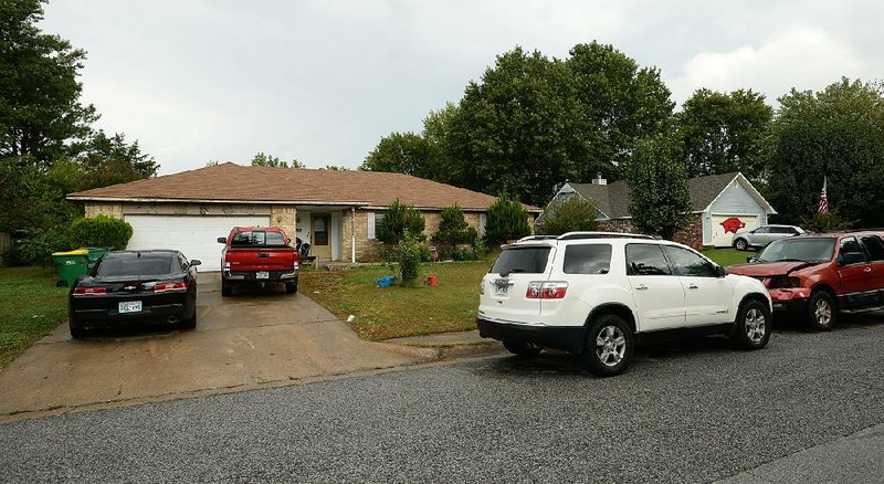 Cars sit outside a house Thursday at 2006 Cardinal Drive in Springdale that federal investigators say was used to house pregnant women who were lured from the Marshall Islands to give birth and then give up their babies for adoption in violation of a treaty between the islands and the U.S. government. 