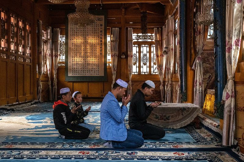 A Hiu family prays at a Muslim shrine built in the Chinese style, in Linxia, China. In 2018, President Xi Jinping first raised the issue of what he called the “Sinicization of Islam” in 2015, saying all faiths should be subordinate to Chinese culture and the Communist Party. 