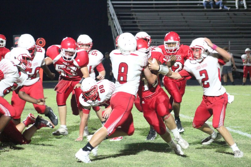 Magnolia freshman quarterback Dalen Blanchard fights for yards against two Camden Fairview defenders.