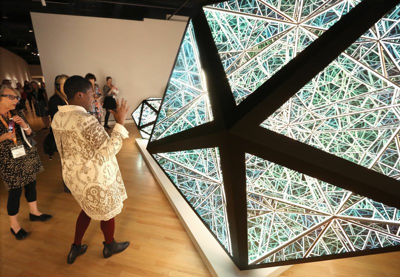 Lauren Haynes, curator at Crystal Bridges Museum of American Art, describes Thursday the steel, glass and light emitting diode art Portal Icosahedron by Anthony James during a media tour of “Crystals in Art: Ancient to Today” exhibition at the Bentonville museum. The exhibit features 75 objects and 10 crystal specimens and runs from Saturday to Jan. 6. 