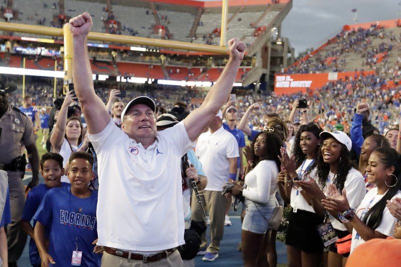 Florida head coach Dan Mullen celebrates in front of fans as he leaves the field after defeating Auburn in an NCAA college football game, Saturday, Oct. 5, 2019, in Gainesville, Fla. (AP Photo/John Raoux)