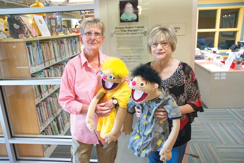 Nancy Provost, left, holds a puppet made to resemble her late grandson, Keagan Provost, and Pat Hoisager-Ellis, children’s librarian, holds a puppet made to look like Keagan’s brother. The children’s area of the Mary I. Wold Cleburne County Library in Heber Springs has been named the Keagan Provost Children’s Library. Keagan, who lived in Conway and later Maumelle, loved to go to the library when he visited his grandmother.