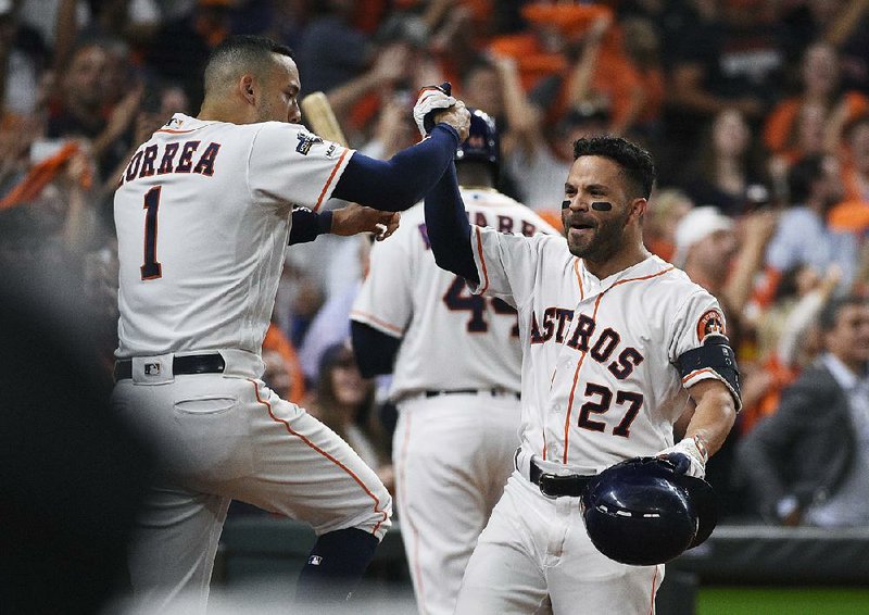 Houston Astros second baseman Jose Altuve (27) celebrates his solo home run against the Tampa Bay Rays with Carlos Correa during the eighth inning of the Astros’ 6-1 victory in Game 5 of the American League division series Thursday. The Astros meet the New York Yankees in the American League Championship Series starting tonight. 