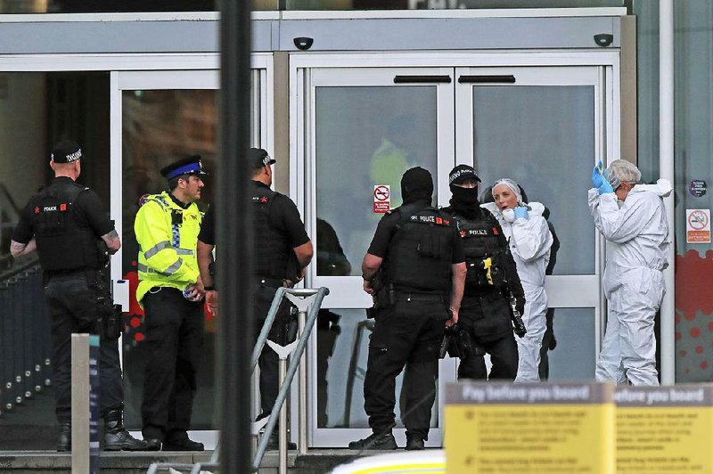 Investigators work outside a shopping center Friday in Manchester, England, where a knife-wielding attacker chased shoppers and police. 