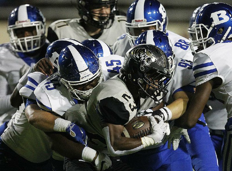 Little Rock Central running back Sam Franklin (23) is tackled by Bryant linebacker Austin Bailey (45) and a pack of defenders during the first quarter of Bryant’s 55-14 victory on Oct. 11 at Quigley Field in Little Rock. More photos are available at arkansasonline.com/1012bryant/.