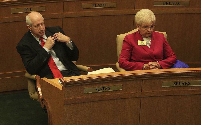 Mickey Gates takes off his legislative lapel pin after Friday’s vote expelling him from the House. Rep. Nelda Speaks (right), R-Mountain Home, joined in voting to oust Gates. 