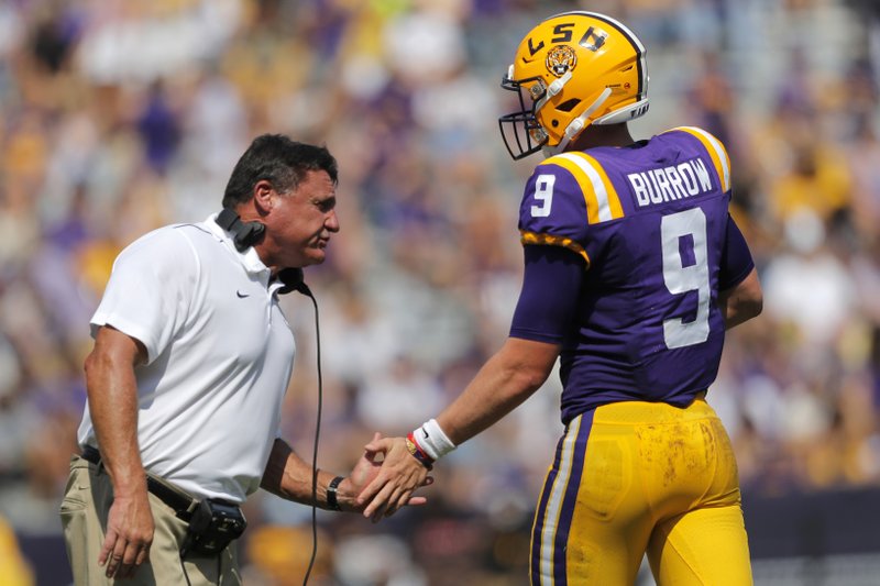 LSU head coach Ed Orgeron congratulates quarterback Joe Burrow (9) after he scored a touchdown in the first half of an NCAA college football game against Utah State in Baton Rouge, La., Saturday, Oct. 5, 2019. (AP Photo/Gerald Herbert)