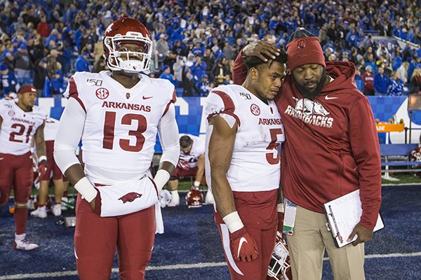 Arkansas quarterback K.J. Jefferson (13), running back Rakeem Boyd (5) and a staff member react after the Razorbacks' 24-20 loss to Kentucky on Saturday, Oct. 12, 2019, in Lexington, Ky. 