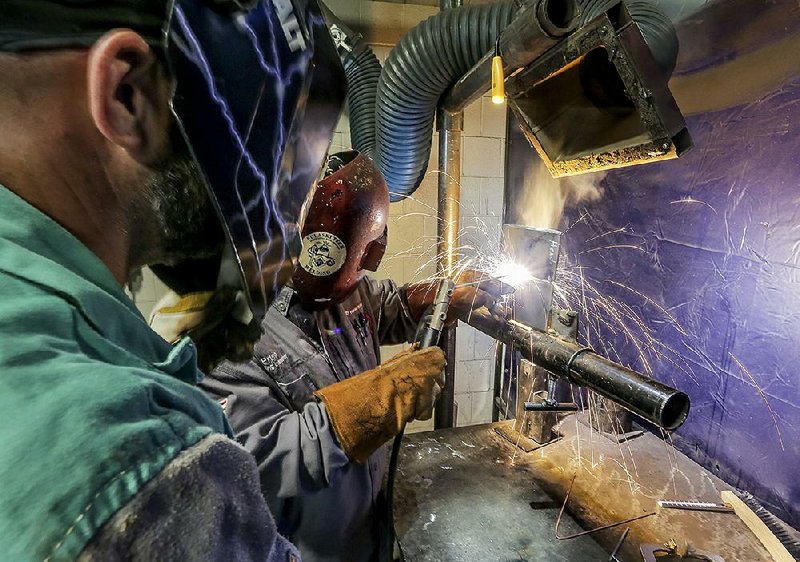 Instructor Primo Voisin demonstrates a technique for student Jason Hendrix during a welding class at University of Arkansas- Pulaski Technical College. More photos are available at arkansasonline.com /1013/training/ 