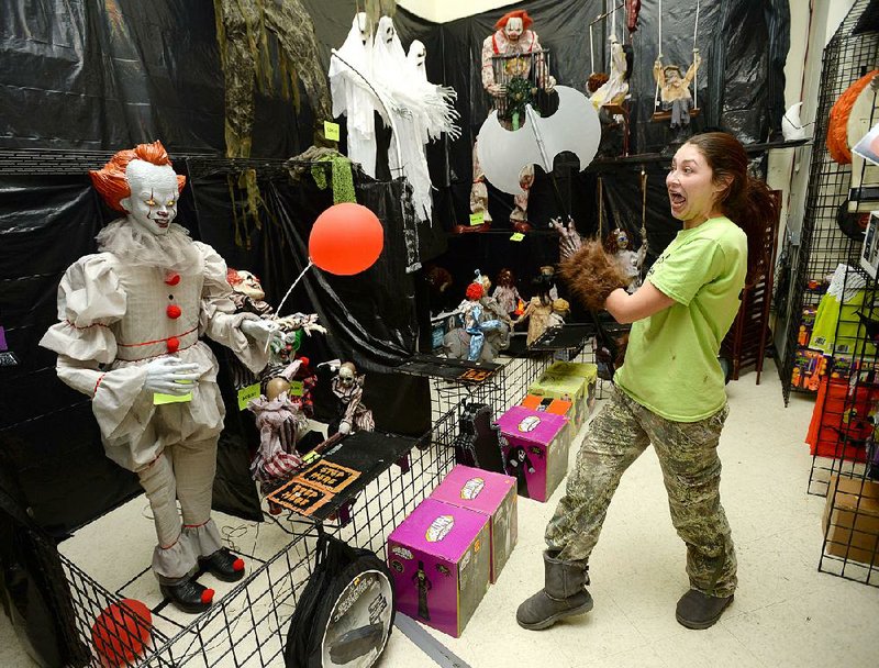 Meredith Cordoza, an employee at Halloween Express, plays with an animated Pennywise figure Wednesday at the store in the Frisco Station Mall in Rogers. More photos are available at arkansasonline.com/1013halloween/ 